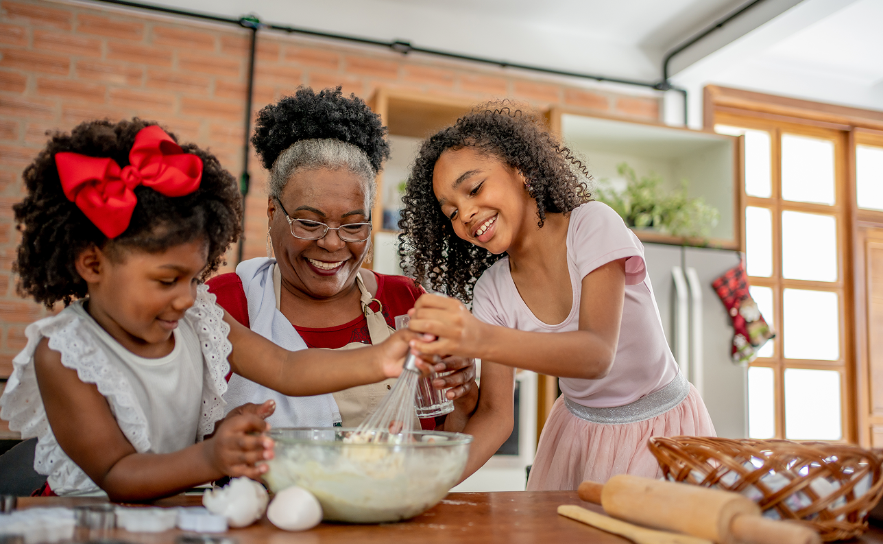 Grandmother making cakes with her granddaughters