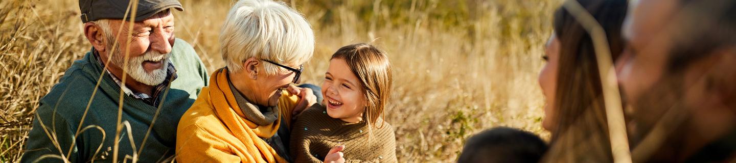 Old couple playing in a wheat field with a young girl