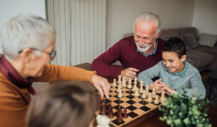 Grandparents playing chess with grandchildren