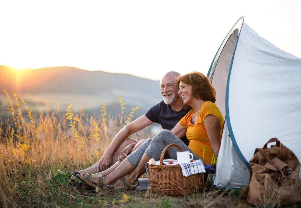 Couple sat in tent with picnic basket