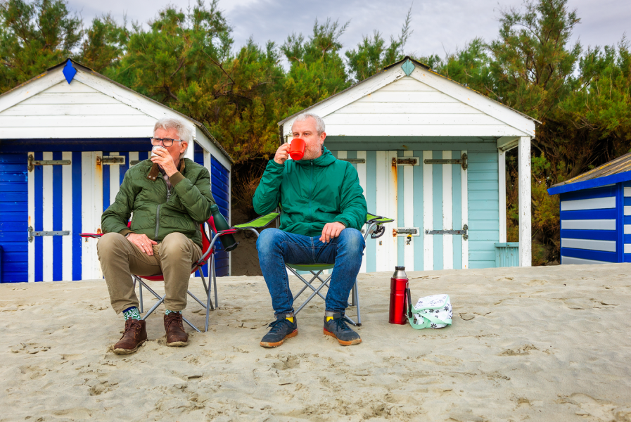Two men on beach chairs looking into the distance