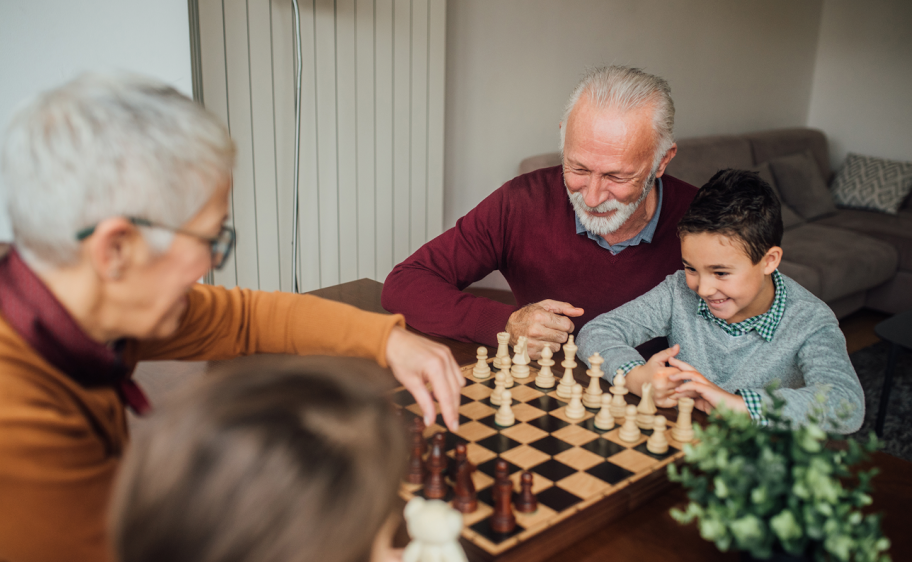 Grandparents playing chess with grandchildren